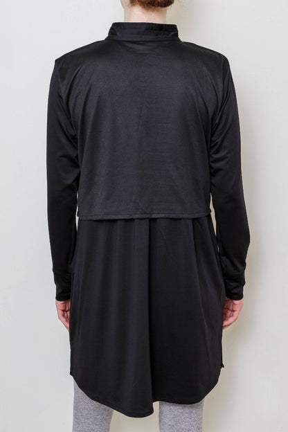 Person wearing a black long-sleeve top against a white background
