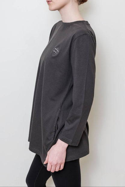 Person wearing a dark gray long-sleeve shirt against a white background